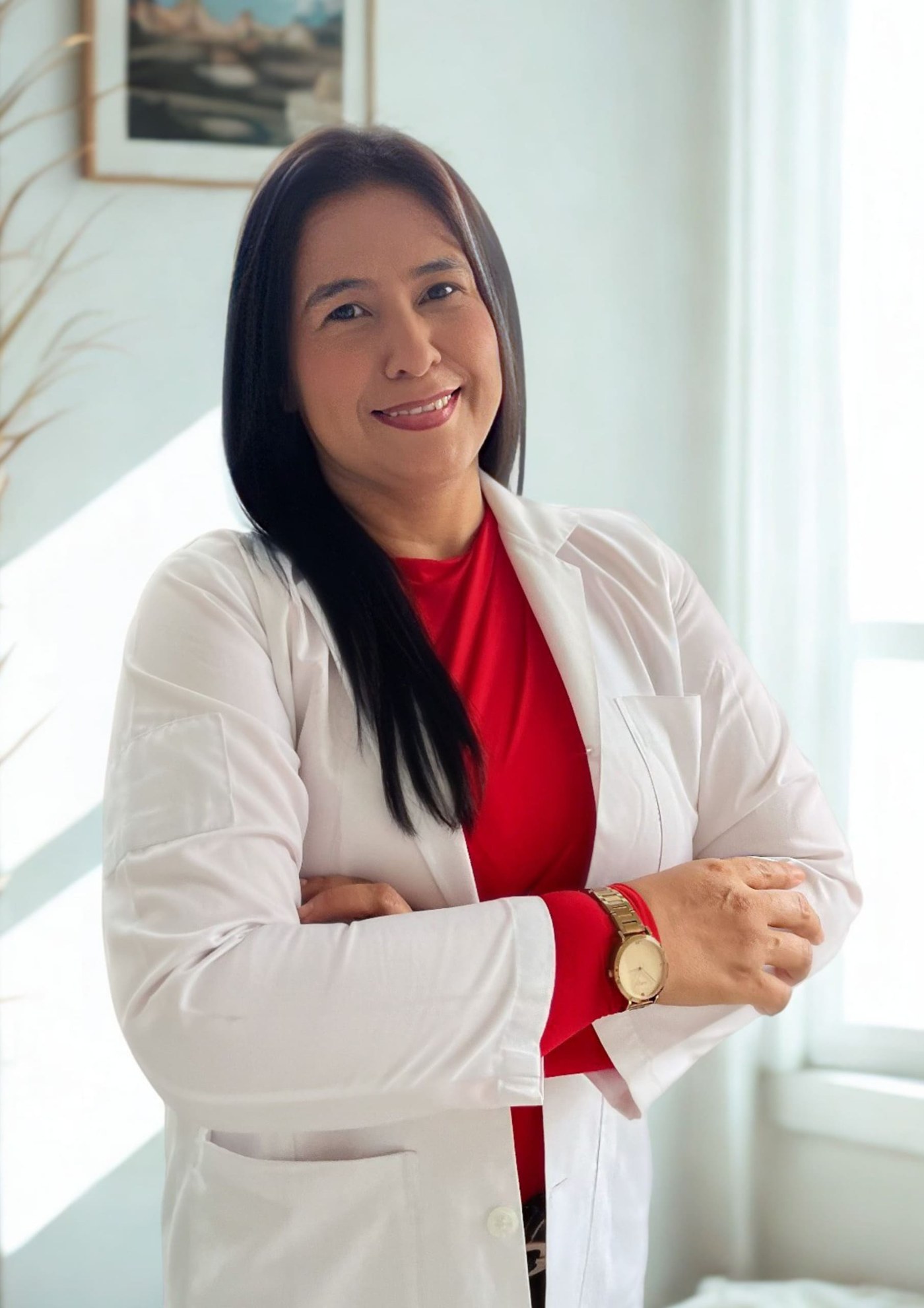 La psicóloga Diana Figueroa de bata blanca y blusa roja en su consultorio